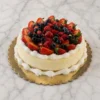 Cheesecake clásico redondo sobre una base de galleta, adornado con elegantes bordes acanalados de crema batida en la parte superior y en la base. El centro está coronado con una abundante y brillante mezcla de frutos rojos frescos, que incluye fresas, frambuesas y arándanos. Castillo's Cake Shop.