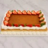 Atractivo pastel rectangular tipo plancha con una superficie cubierta de una suave capa de cajeta o dulce de leche. Está enmarcado por tupidos bordes de crema batida blanca y decorado con mitades de fresas frescas alrededor de todo el perímetro. Castillo's Cake Shop.
