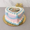 Pastel en forma de corazón con base color rosa pastel, decorado con elaborados bordes de glaseado entrelazado en tonos azul claro y blanco estilo Lambeth. En el centro superior lleva una colorida imagen comestible con personajes de Sanrio sobre un arcoíris y está coronado con un letrero dorado de "HAPPY BIRTHDAY". Castillo's Cake Shop.