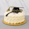 Pastel redondo de un piso completamente cubierto de hermosos rosetones de glaseado blanco (estilo rosette cake). En la cima está decorado de manera sobria con un birrete negro de graduación con borla dorada, un diploma enrollado con un listón negro y un elegante letrero dorado en acrílico que dice "Graduate". Castillo's Cake Shop.