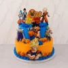 Pastel de dos pisos con temática de Dragon Ball. El piso inferior es de color naranja brillante con bordes de rosetones azules, decorado con las esferas del dragón y una figura central de Goku. El piso superior es azul con textura de líneas horizontales. La decoración superior incluye figuras de Goku, Vegeta, Piccolo, Broly, Shenlong y un letrero personalizado que dice "28 Juan Pablo Dragon Ball". Castillo's Cake Shop.