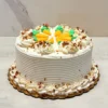 Pastel de Zanahoria Pastel redondo con glaseado blanco de líneas horizontales. Su decoración incluye detalles temáticos encantadores: pequeñas zanahorias hechas con glaseado naranja y verde en el centro, complementadas con rosetones blancos y nueces picadas esparcidas tanto en la corona como en el borde inferior.