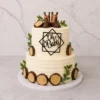 Pastel de dos pisos con textura de sutiles líneas horizontales y temática rústica. Está bellamente adornado en su perímetro con rebanadas de tronco de madera hechas de fondant y hojas verdes. En la cima lucen unas pequeñas botas vaqueras de fondant junto a un letrero geométrico negro que dice "Oh Baby". Castillo's Cake Shop.